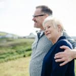 An elderly couple standing outdoors.