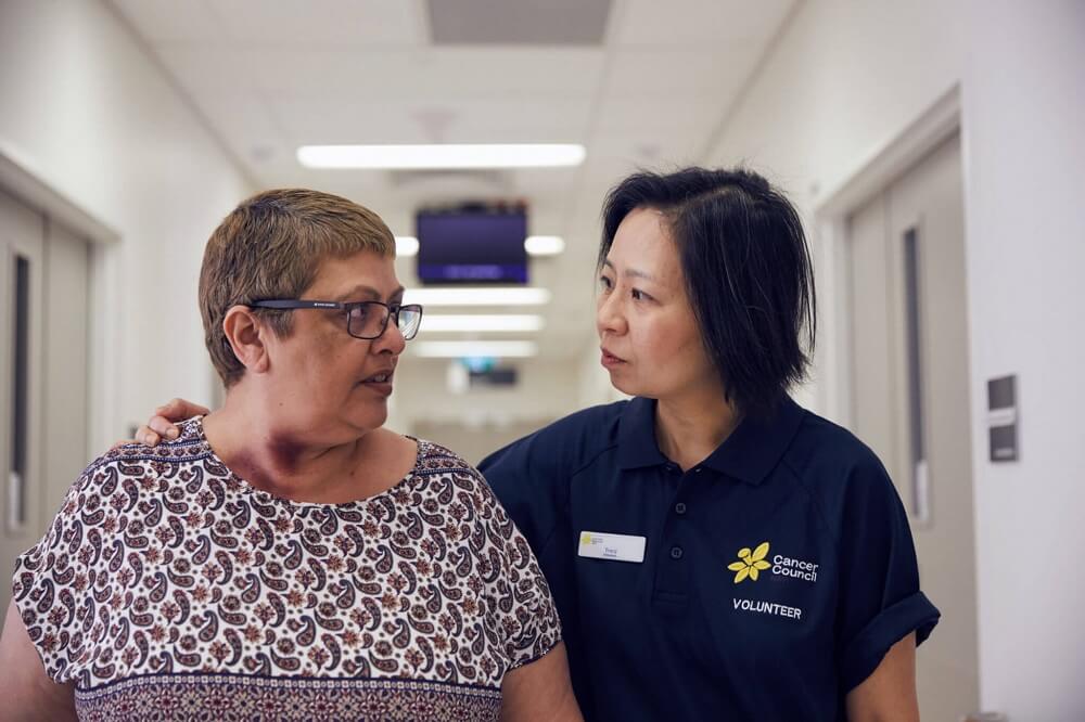 A volunteer assists a patient in the hospital