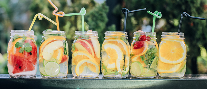 Jars of healthy drinks with straws. 