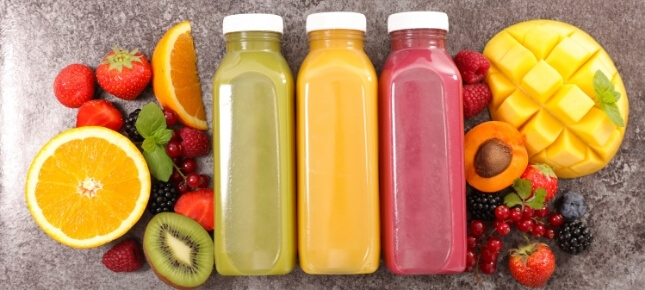 Assorted bottles of juice and fruit pieces