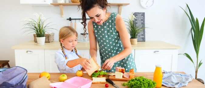 Mother and daughter packing a healthy lunch.