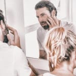 Couple checking their skin for cancer.