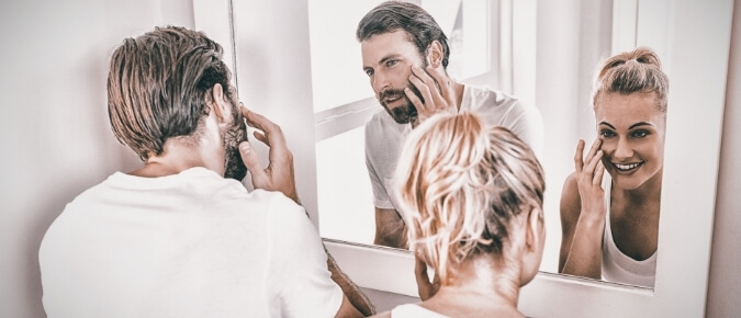 Couple checking their skin for cancer.