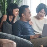 Young Asian family looking at a laptop at home