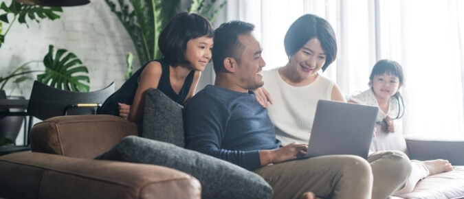 Young Asian family looking at a laptop at home