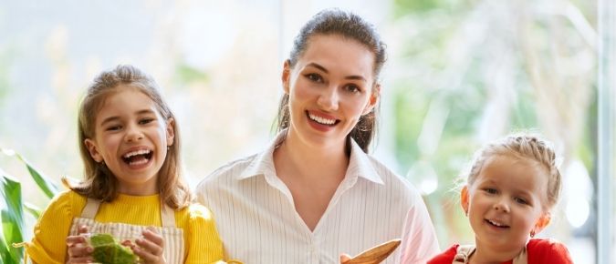 Young woman and two girls smiling. 