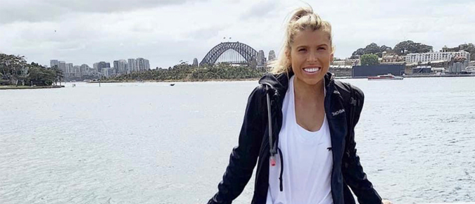 Young blonde woman standing in front of the Harbour Bridge.