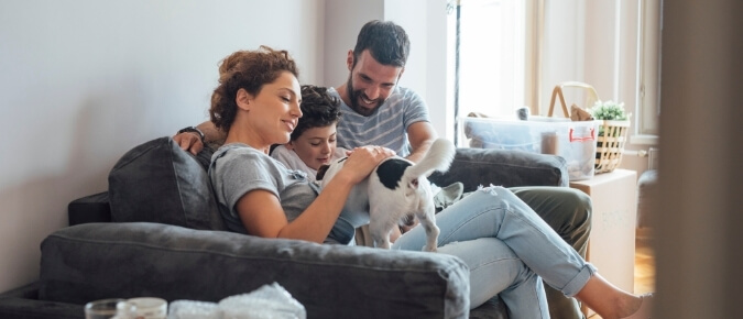 Young family sitting on the couch at home.