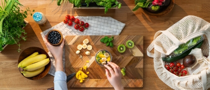 Top view of a woman's hands preparing a fruit smoothie.