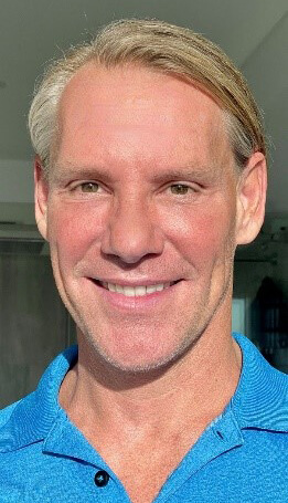 Blonde man smiling.