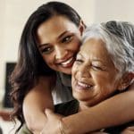 Younger woman hugging older woman.
