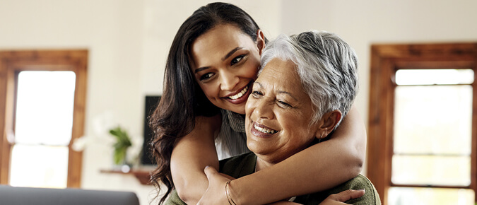 Younger woman hugging older woman. 