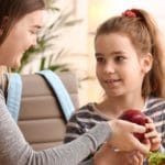 Mother packing lunch for daughter.