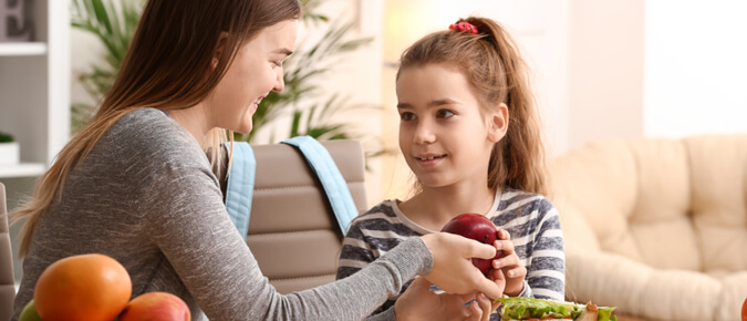 Mother packing lunch for daughter.