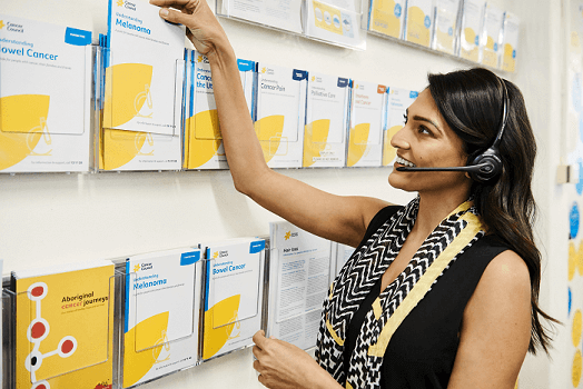Cancer council staff picking out a cancer information pamphlet