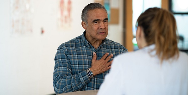 man holding his hand on his chest, talking to a lady