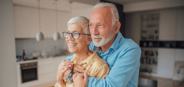 old couple hugging and looking into the distance