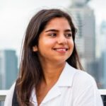 girl in white shirt looking sideways smiling