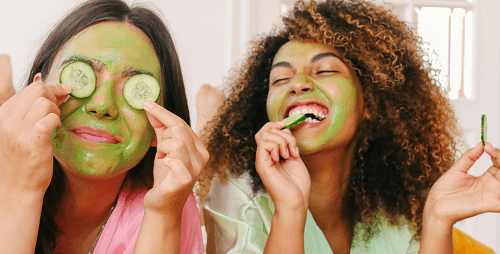 two girls doing self care with a mask and cucumbers