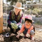 mother and daughter creating a vegie patch in garden