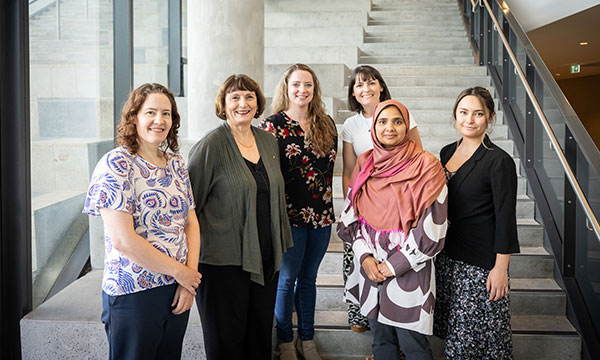 A group of researchers standing on stairs at the launch of the Daffodil Centre
