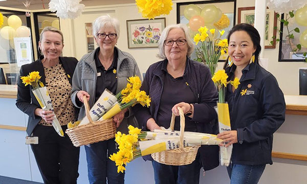 Volunteers and staff holding daffodils