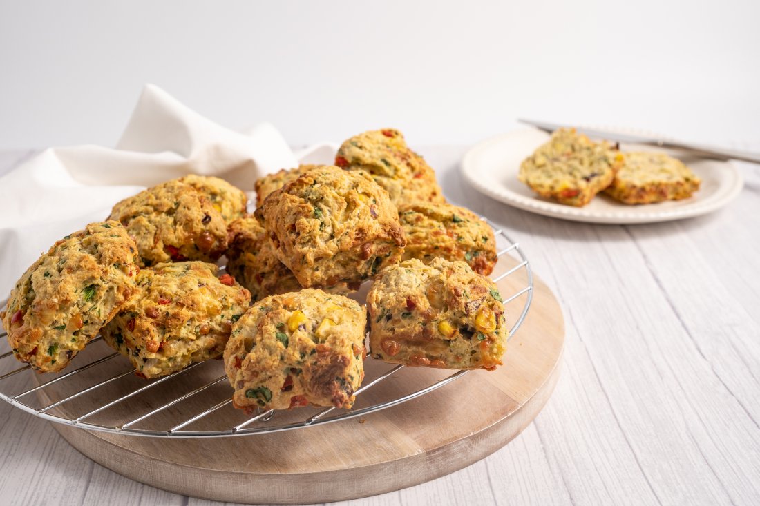 A photo of savoury scones, served on a wooden serving board.