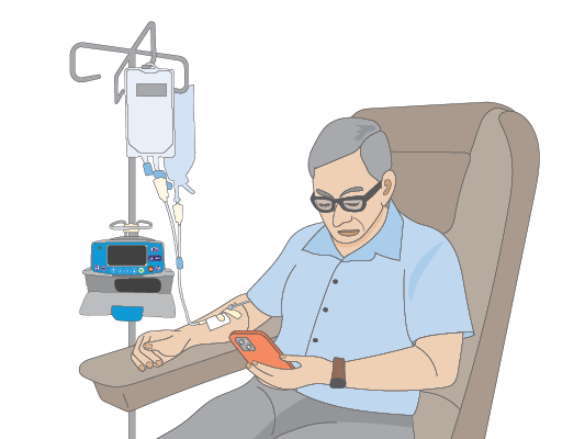 Image of man getting chemotherapy and looking at his phone.