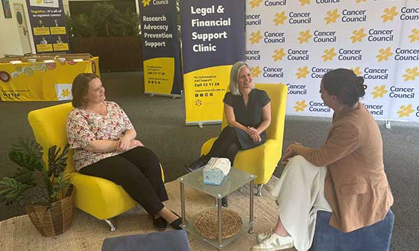 Three women speak in office chairs