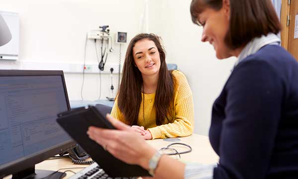 A woman speaks with her doctor